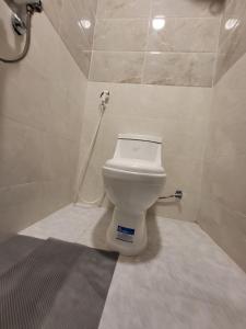 a bathroom with a toilet with a hose at Traveler Rooms in Medina