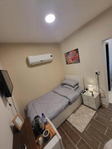 Dormitorio pequeño con cama y aire acondicionado en Traveler Rooms en Medina