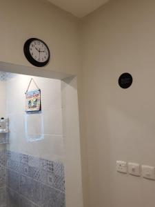 a clock on the wall of a bathroom with a shower at Traveler Rooms in Medina