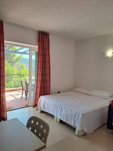 a bedroom with a bed and a view of a patio at Allegroitalia Elba Golf in Portoferraio