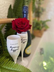 a vase with a rose and a bottle of wine at LOVER'S ROOM TROPIC in Verton