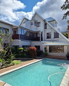una casa con piscina frente a ella en Clarence House en Ciudad del Cabo