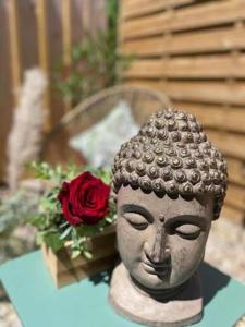 a statue of a head on a table with a red rose at LOVER'S ROOM TROPIC in Verton