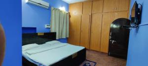a bedroom with a bed and a blue wall at Feel Lyk Home in Visakhapatnam
