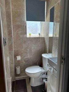 a bathroom with a toilet and a sink and a window at Central London - Edgware Road 2 GF Bedroom Flat in London