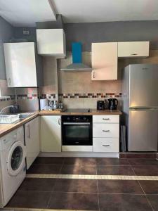 a kitchen with white cabinets and a dishwasher at Central London - Edgware Road 2 GF Bedroom Flat in London