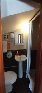 une petite salle de bain avec toilettes et lavabo dans l'établissement Guesthouse, Ap Veríssimo, à Nazaré