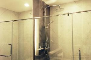 een badkamer met een douche en een glazen deur bij Astra White Suite 12 in Chiang Mai