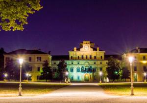 ein Gebäude mit einem Uhrturm darüber in der Nacht in der Unterkunft Peppe Home Fontana del Trianon in Parma
