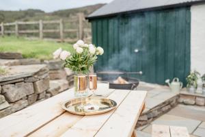 un tavolo con un vaso di fiori bianchi sopra di Gleann Cottage - Seasgair Lodges a Kincraig