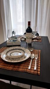 拉斯佩齊亞的住宿－Green Central house，一张桌子,上面放着盘子和一瓶葡萄酒