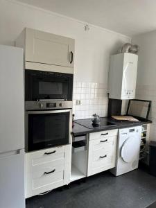 a kitchen with white cabinets and a black counter top at résidence Garches -St Cloud in Rueil-Malmaison