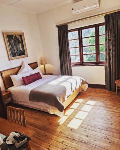 sypialnia z dużym łóżkiem i dużym oknem w obiekcie Clarence House w Kapsztadzie