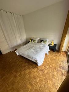 a bedroom with a white bed and a wooden floor at résidence Garches -St Cloud in Rueil-Malmaison
