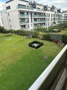 a green yard with a bench and a building at résidence Garches -St Cloud in Rueil-Malmaison