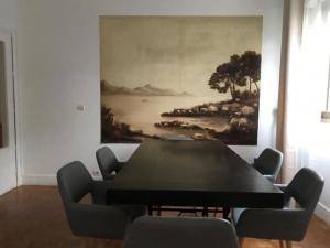 a dining room with a table and chairs and a painting at résidence Garches -St Cloud in Rueil-Malmaison