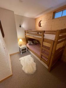 1 Schlafzimmer mit 2 Etagenbetten und einem weißen Teppich in der Unterkunft Appartement - Villars Sur Ollon in Villars-sur-Ollon