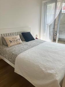 耶德库安特Rimos apartamentai Juodkranteje的卧室里有一张白色的大床，床边有一扇窗户 更多5张照片