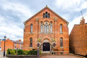 a red brick church with a black door at The Old Chapel Apartment in Chester