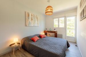 une chambre avec un lit avec deux oreillers rouges dans l'établissement Le Blue Sea - Appt T3 classé 3 étoiles à 650m de la plage, au Lavandou