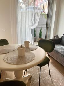 耶德库安特Rimos apartamentai Juodkranteje的一间设有两张桌子、椅子和一张沙发的房间