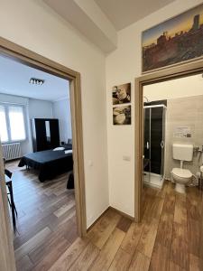 una camera con una camera da letto, un letto e uno specchio di GioiaHomes a Milano