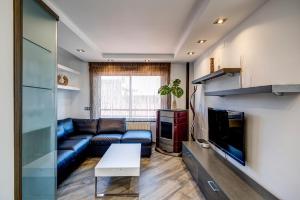 a living room with a couch and a tv at Dreams Port Cambrils Apartment in Cambrils