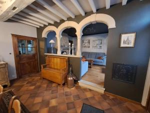 een woonkamer met gewelfde plafonds en een kamer met een bank bij Gîte L'Hôte-Antique in Bouillon