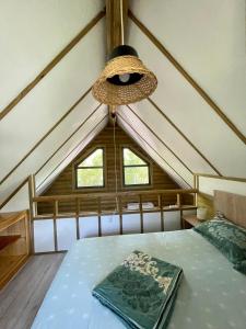 a bed in a room with a roof at Lake Side - Lângă Lac in Dunavăţu de Jos