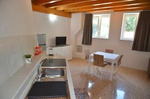 eine Küche mit einem Waschbecken und einem Tisch mit Stühlen in der Unterkunft Palazzo Maggiore Suite A in Noale
