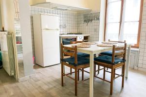 a kitchen with a table with chairs and a refrigerator at Marx Residence T2 4 personnes - Wifi #EA in Grenoble