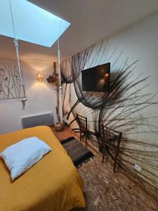 Un dormitorio con una cama y un televisor en la pared. en Gite De Charme, en Ganac
