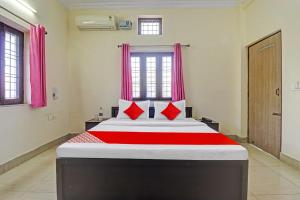 a bedroom with a large bed with red pillows at Balindira Guest House in Dehradun