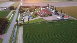 an aerial view of a house with cars parked in a driveway at Trekkershut De Tulpenweide in Breezand