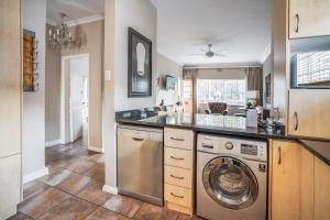 a kitchen with a washer and dryer in it at Avemore Vredehof No 2 - with Backup Power in Stellenbosch