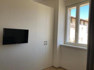 Habitación con TV de pantalla plana en una pared blanca. en Al Palazzo, en Cles
