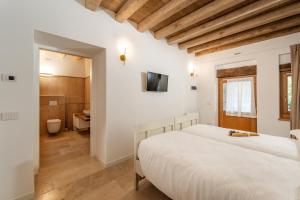 a bedroom with a bed and a bathroom at Agriturismo Il Bosco Camere in Vittorio Veneto