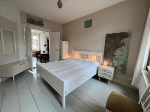 a bedroom with a large white bed and a desk at Am Hafen 13 in Glückstadt
