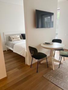 耶德库安特Rimos apartamentai Juodkranteje的一间卧室，配有一张床、一张桌子和几把椅子