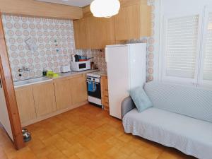 a small kitchen with a couch and a refrigerator at Costa brava apartment, Estartit in Torroella de Montgrí