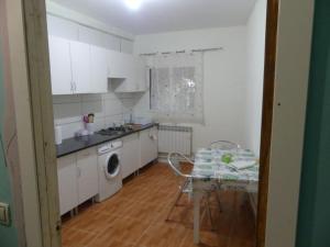eine Küche mit weißen Schränken, einem Tisch, einem Tisch und einem Stuhl in der Unterkunft VILLA LOS MOLINOS in Candeleda