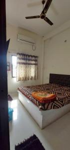 Schlafzimmer mit einem Bett und einem Deckenventilator in der Unterkunft OYO Flagship Hotel Royal Galaxy in Nagpur