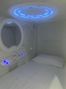 a room with a toilet with blue lights on it at flor hostel capsules in Madrid