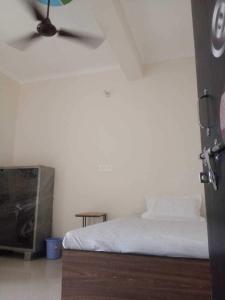 a bedroom with a bed and a ceiling fan at OYO Bhavya Guest House in Morādābād