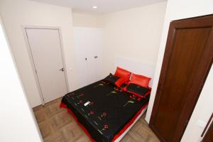 Un dormitorio con una cama con almohadas rojas. en Sweet Home 2 in Shekvetili en Shekhvetili