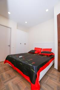 sypialnia z łóżkiem z czerwonymi poduszkami w obiekcie Sweet Home 2 in Shekvetili w mieście Shekhvetili