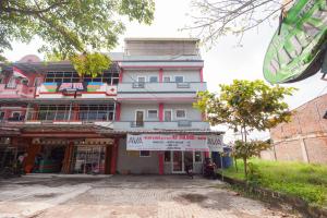 a building with a sign in front of it at AVA Guesthouse Mitra RedDoorz Lampung in Bandar Lampung