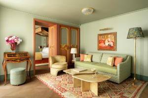 een woonkamer met een bank en een tafel bij Le Grand Mazarin in Parijs