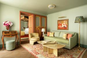 a living room with a couch and a table at Le Grand Mazarin in Paris