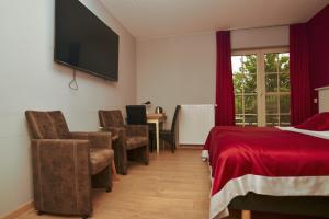 1 dormitorio con 1 cama y TV en la pared en B&B Fruithof Tack en Sint-Gillis-Waas